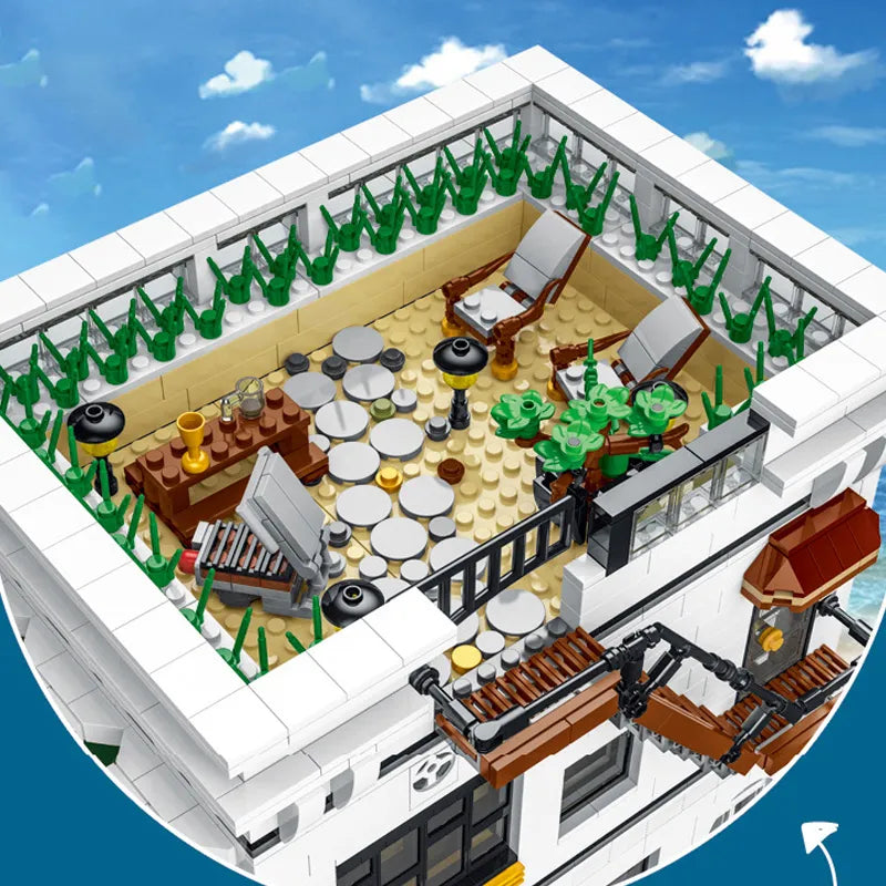 Rooftop patio of modular seafood restaurant building set with lounge chairs, patio tables, and greenery lining the terrace walls.