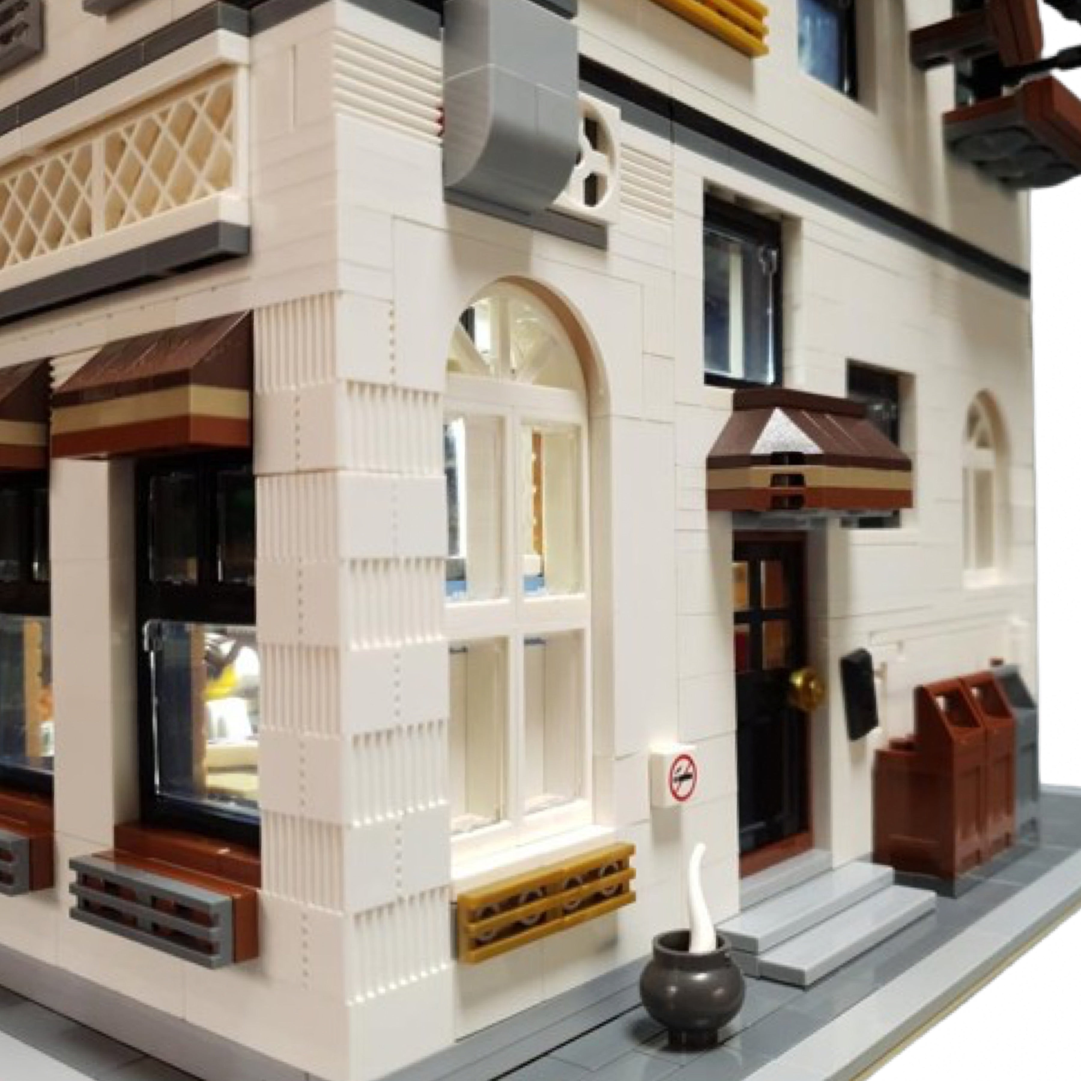 Side entrance of restaurant building block model featuring arched window, brown awning, no smoking sign, and decorative planter.