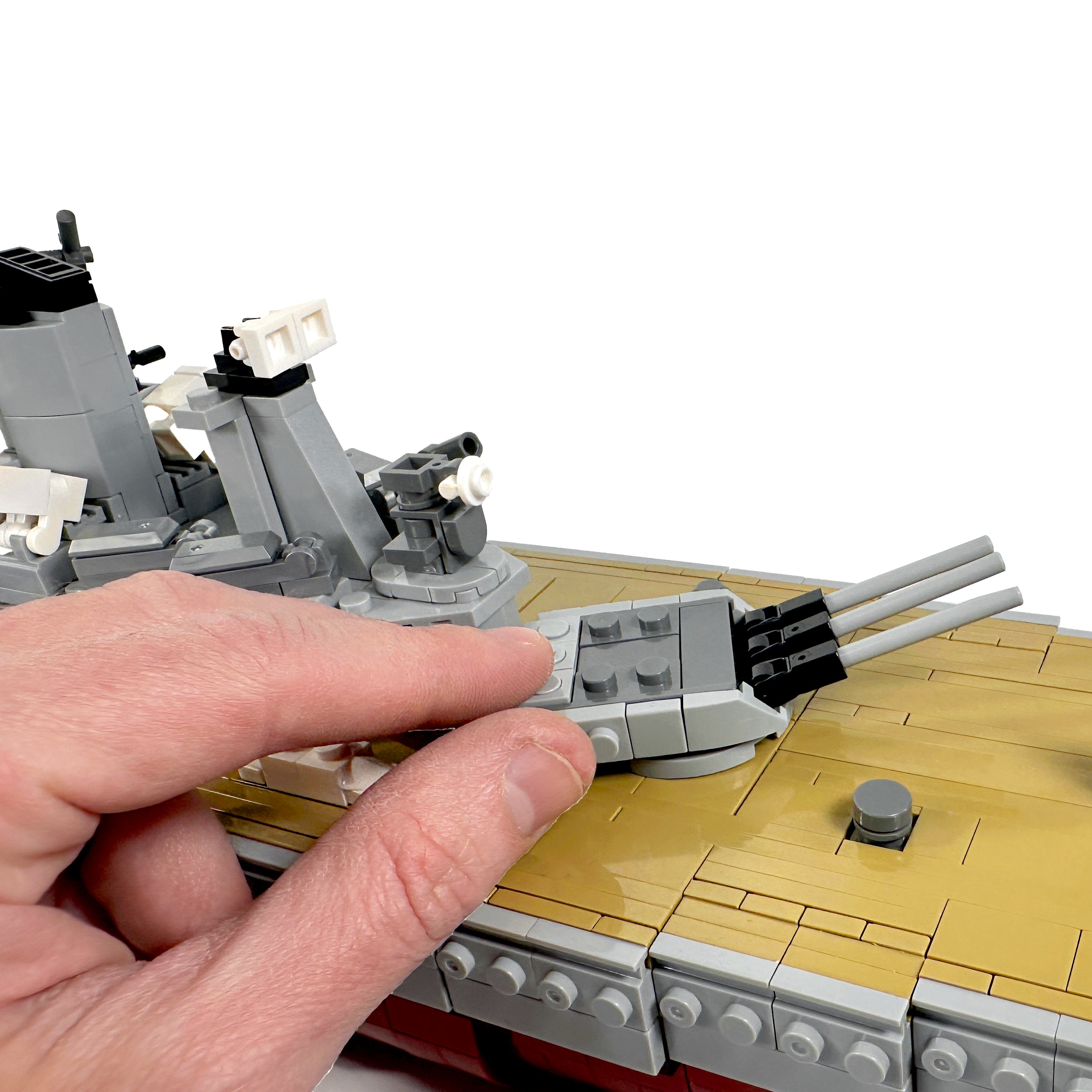Deck weapon detail shot with hand for scale comparison showing battleship guns
