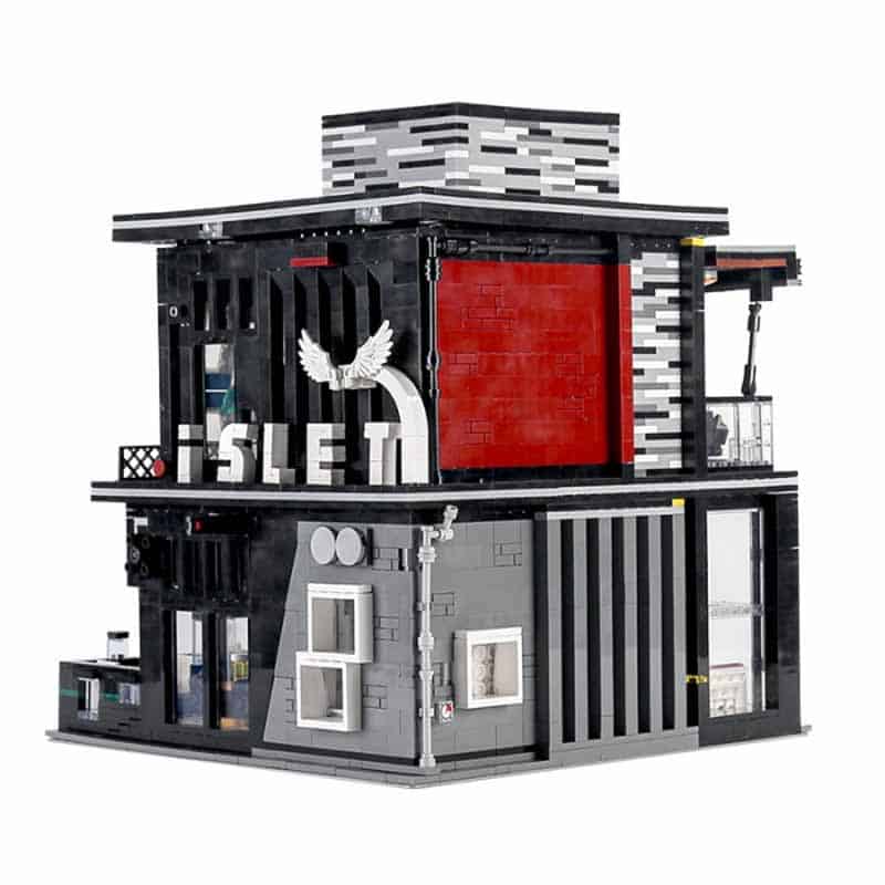 Rear angle of the modular building block pub showing red accent walls, winged signage reading “ISLET,” and architectural details on the exterior.