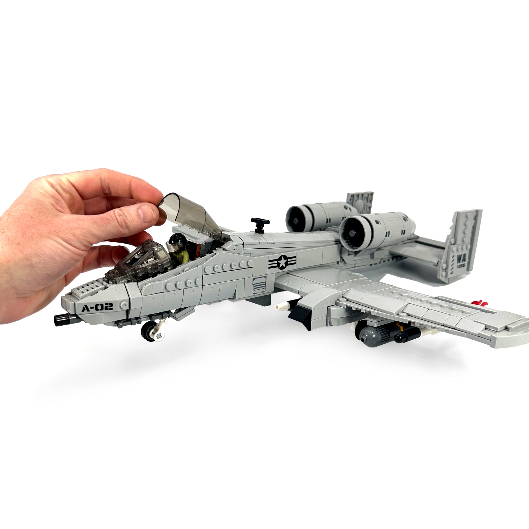 Interactive cockpit of the General Jim’s A-10 Thunderbolt II aircraft model opens to reveal seated pilot minifigurine. 