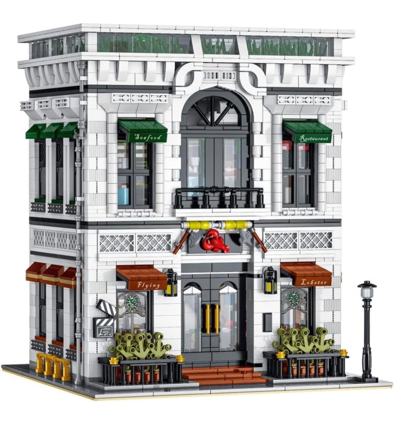 A modular building blocks set resembling a two-story Flying Lobster Seafood Restaurant with detailed storefront, balconies, and a rooftop patio. The color scheme includes white, gray, and brown tones with green awnings.